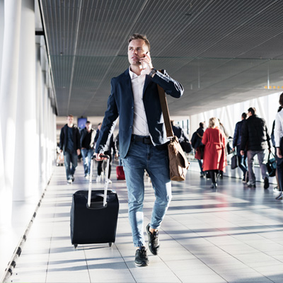 Guy with handluggage and mobile at the airport